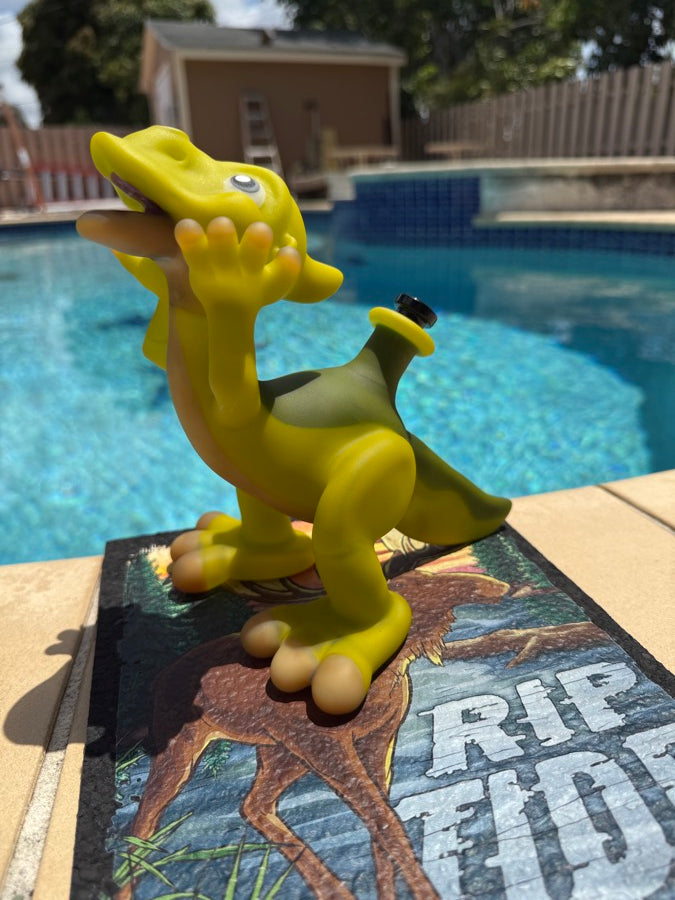 Yellow sculptural borosilicate duckbill rig standing on its artist tile, poolside in Miami